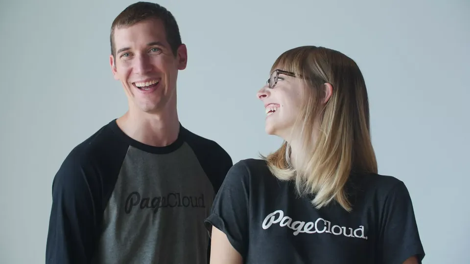 Two Pagecloud teammates in Pagecloud t-shirts laughing together