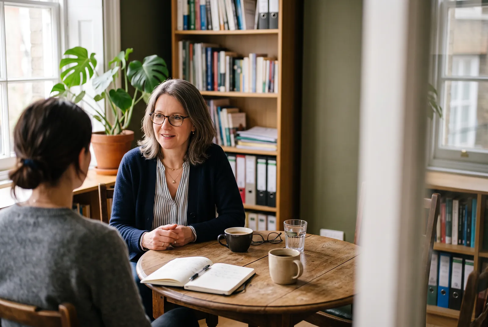 Une consultante à l’écoute d’un futur client, assis en face d’elle dans un bureau lumineux